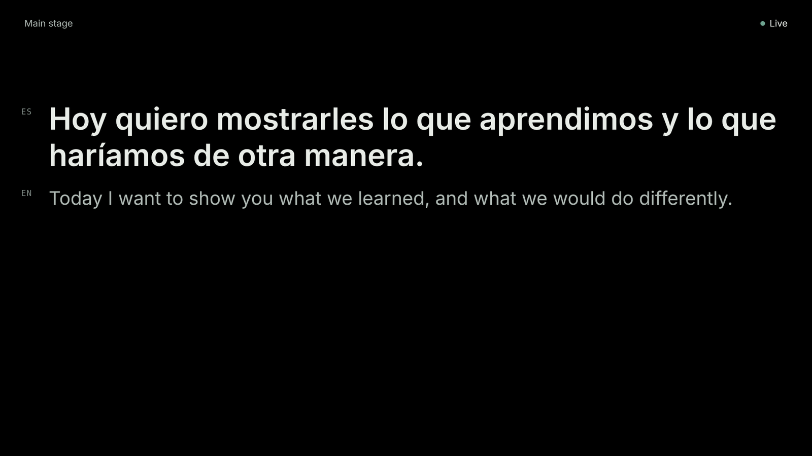 La pantalla del escenario durante una ponencia: la traducción en grande y, debajo, las palabras del ponente.